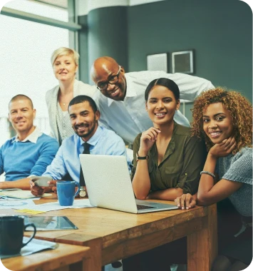 imagem ilustrativa de uma equipe em volta de uma mesa, sorrindo para a foto